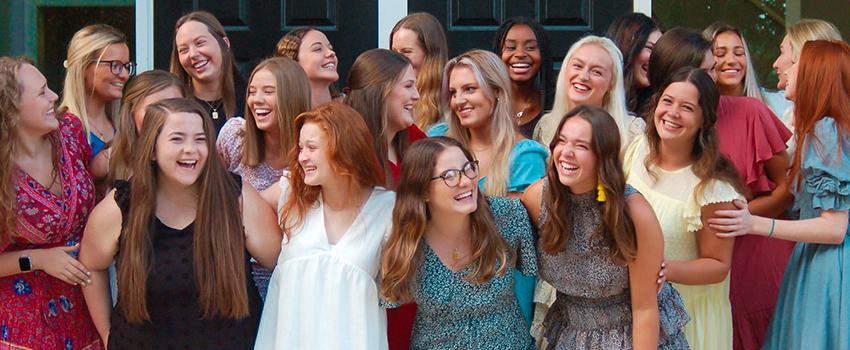 Sorority members smiling and laughing in a group.